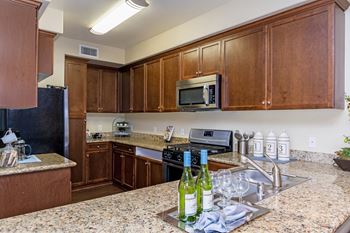 Stainless Steel Whirlpool Appliances in kitchen with wooden cabinet at Rosina Vista in Chula Vista, CA